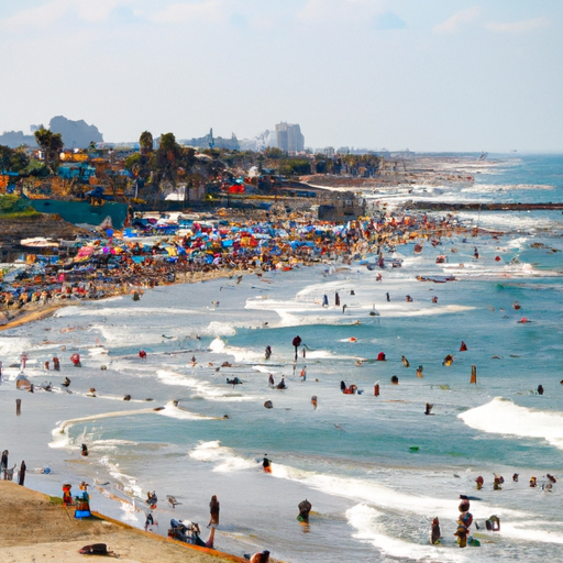 המונים נהנים מהשמש וגולשים בחוף פופולרי בתל אביב